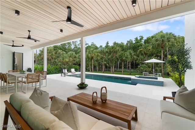 view of swimming pool featuring outdoor lounge area, a patio, an in ground hot tub, and ceiling fan