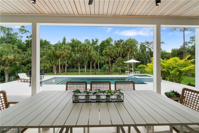 view of pool featuring an in ground hot tub and a patio