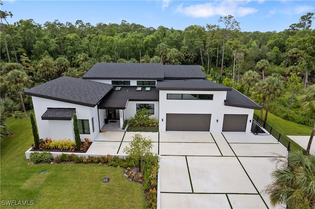 contemporary home featuring a garage and a front lawn