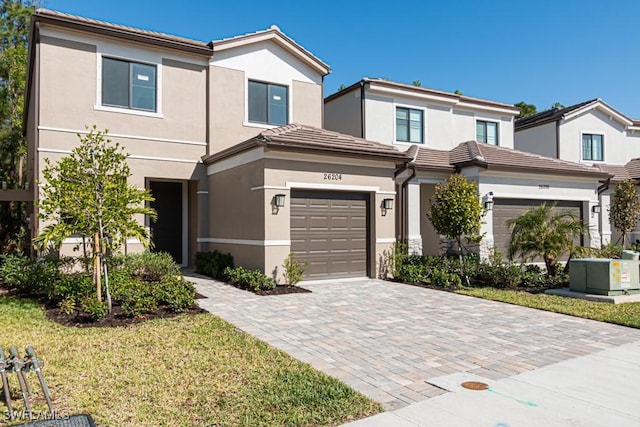 view of front of house featuring a garage, a front yard, and central AC