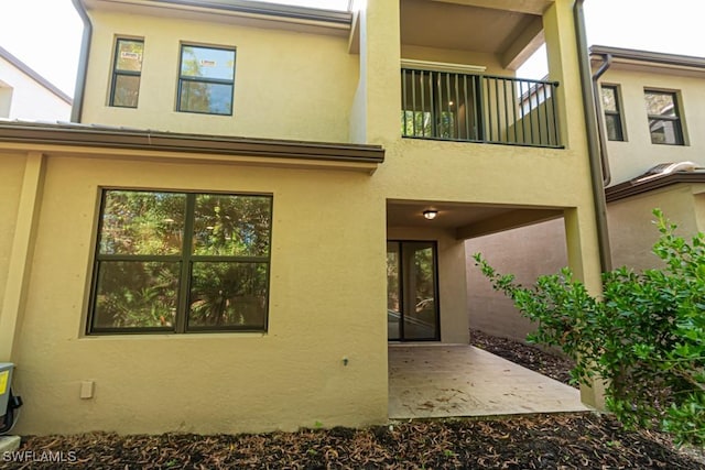 back of property featuring a balcony and a patio