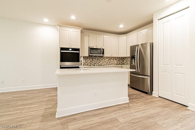 kitchen featuring white cabinetry, sink, stainless steel appliances, and light wood-type flooring