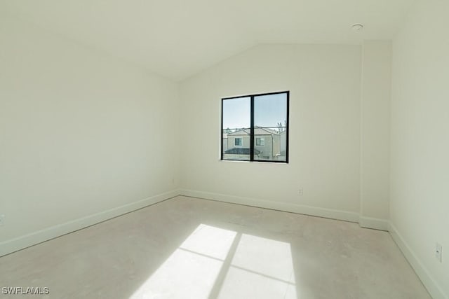 empty room with concrete flooring and vaulted ceiling