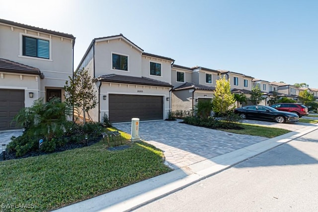 townhome / multi-family property featuring a front lawn and a garage