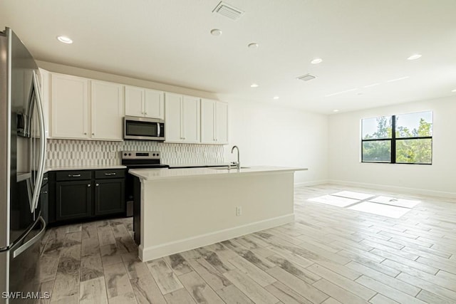 kitchen featuring sink, stainless steel appliances, light hardwood / wood-style flooring, a kitchen island with sink, and white cabinets