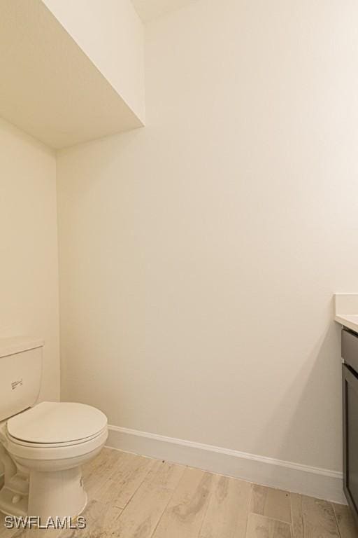 bathroom with vanity, wood-type flooring, and toilet