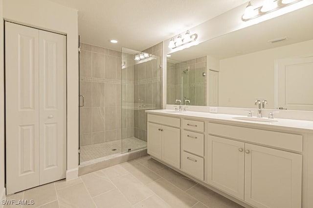 bathroom with tile patterned flooring, vanity, and an enclosed shower