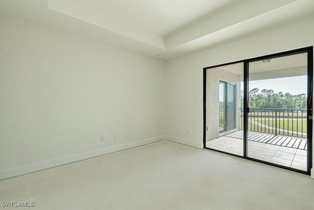 empty room with concrete floors and a raised ceiling