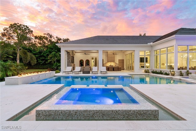 pool at dusk with an in ground hot tub, a patio, and ceiling fan