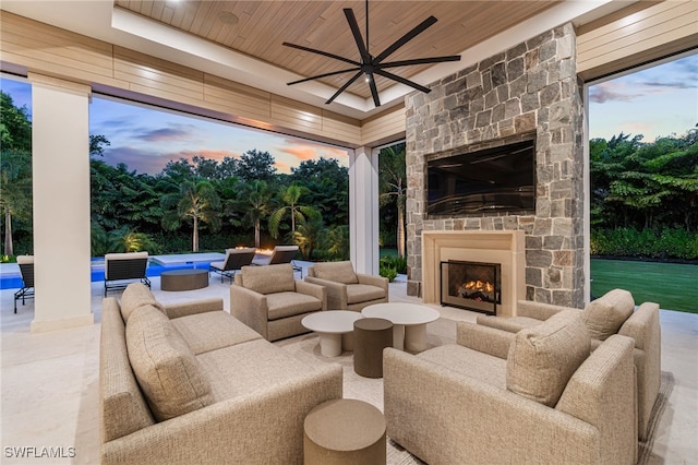 view of patio / terrace with an outdoor living space with a fireplace and ceiling fan