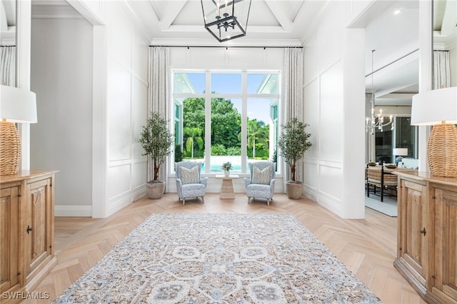 sitting room featuring crown molding, light parquet floors, and a notable chandelier