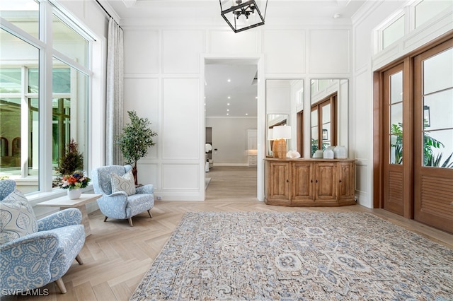 foyer entrance with light parquet flooring and ornamental molding