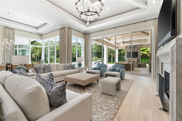 living room featuring light hardwood / wood-style floors, a healthy amount of sunlight, and a tray ceiling