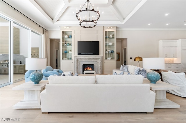 living room featuring crown molding, light hardwood / wood-style flooring, and a chandelier