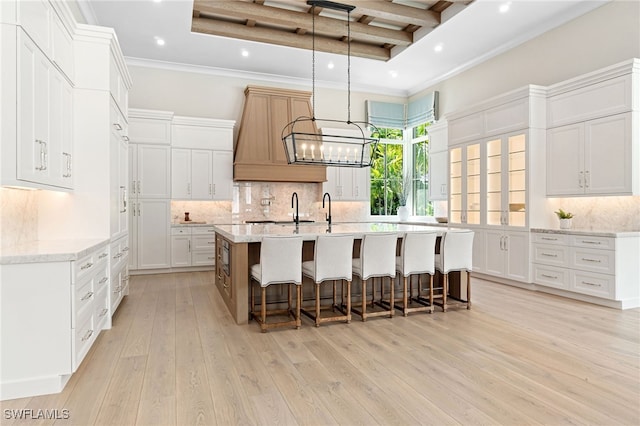 kitchen featuring white cabinets, backsplash, light hardwood / wood-style floors, and beamed ceiling