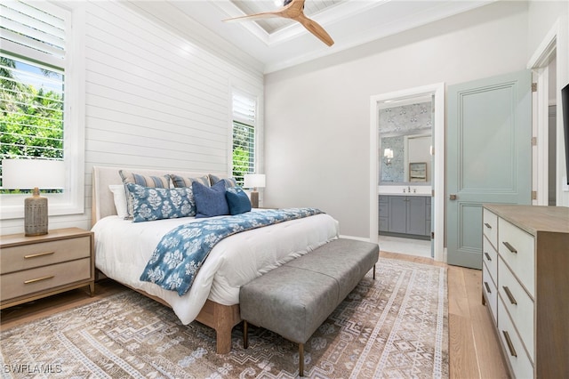 bedroom featuring light wood-type flooring, ensuite bathroom, multiple windows, and ceiling fan