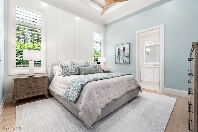 bedroom with ceiling fan, ensuite bathroom, light wood-type flooring, and ornamental molding