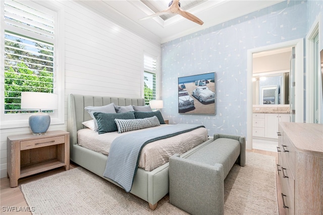 bedroom with ceiling fan, light hardwood / wood-style floors, connected bathroom, and multiple windows