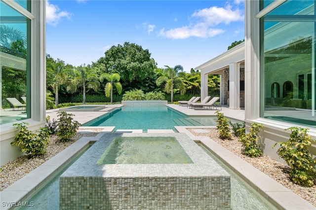 view of swimming pool featuring an in ground hot tub and a patio