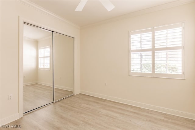 unfurnished bedroom with a closet, light wood-type flooring, a ceiling fan, baseboards, and ornamental molding