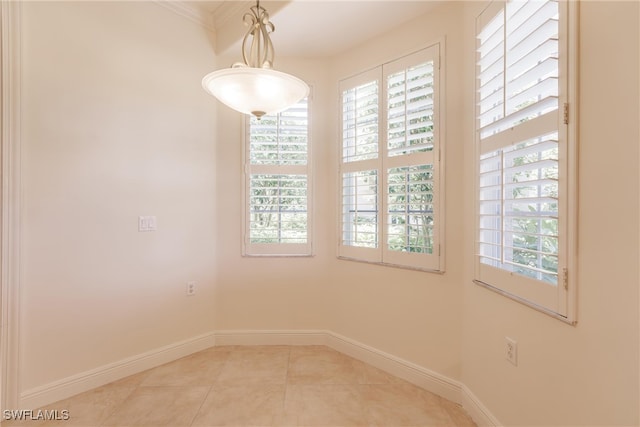 spare room with a wealth of natural light, tile patterned floors, and baseboards
