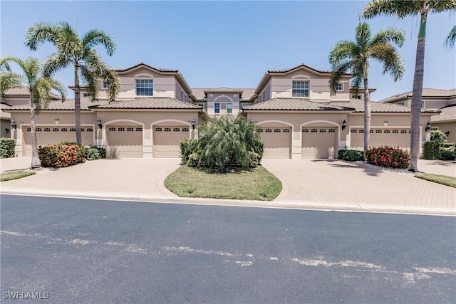 view of front of house featuring stucco siding, decorative driveway, and a garage