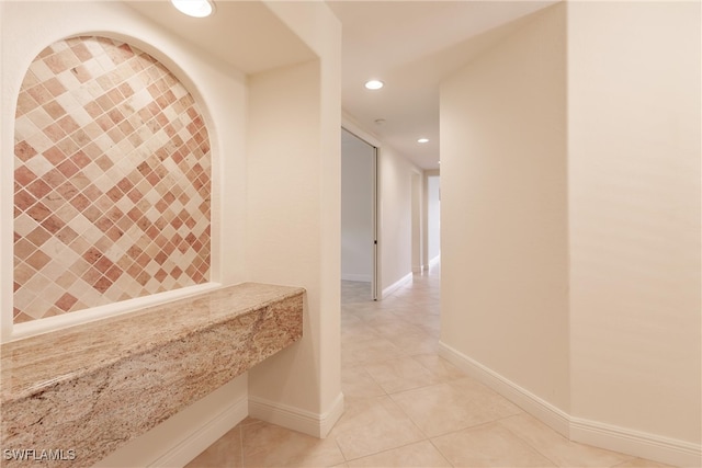 corridor featuring baseboards, recessed lighting, and light tile patterned flooring