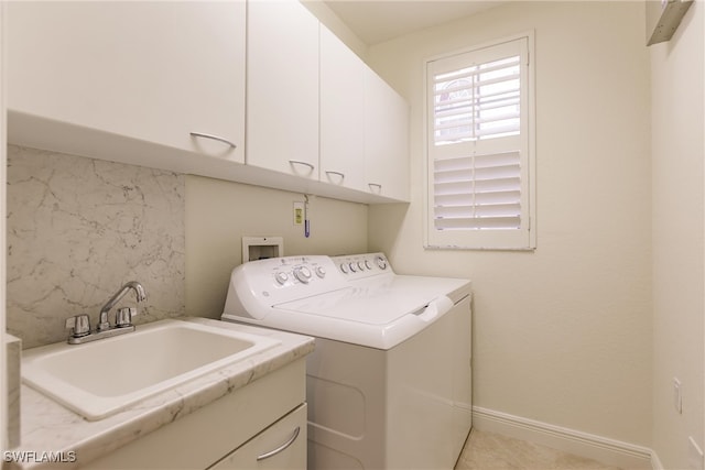 laundry area with a sink, washing machine and dryer, cabinet space, and baseboards