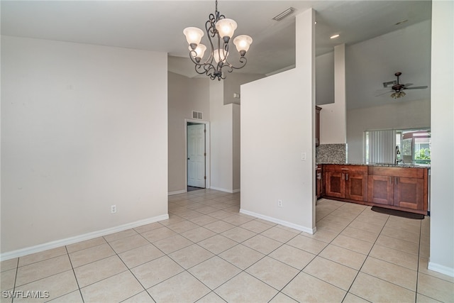 unfurnished room with sink, light tile patterned floors, ceiling fan with notable chandelier, and high vaulted ceiling