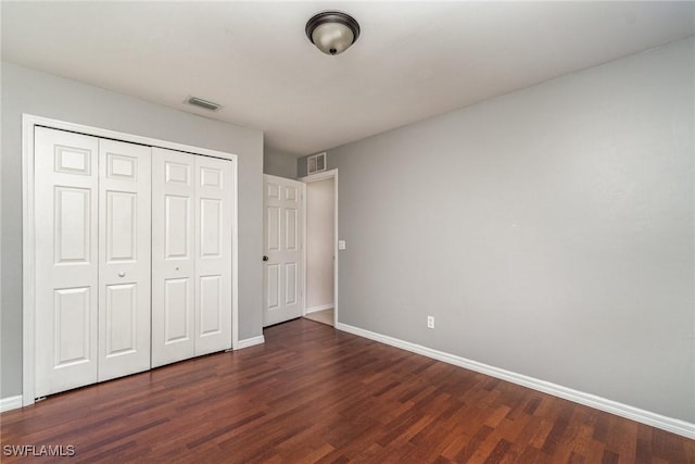 unfurnished bedroom with a closet and dark hardwood / wood-style flooring