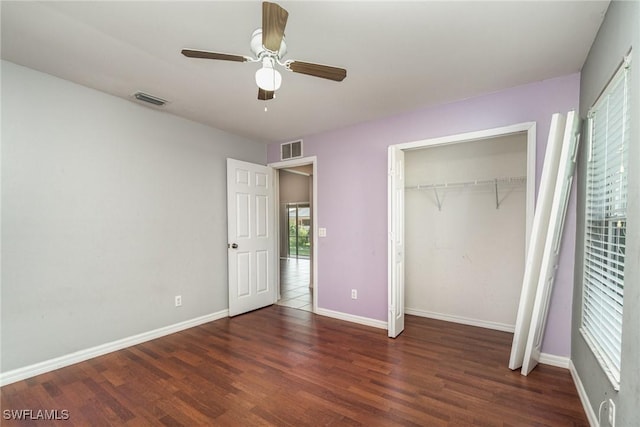 unfurnished bedroom with ceiling fan, dark hardwood / wood-style flooring, and a closet