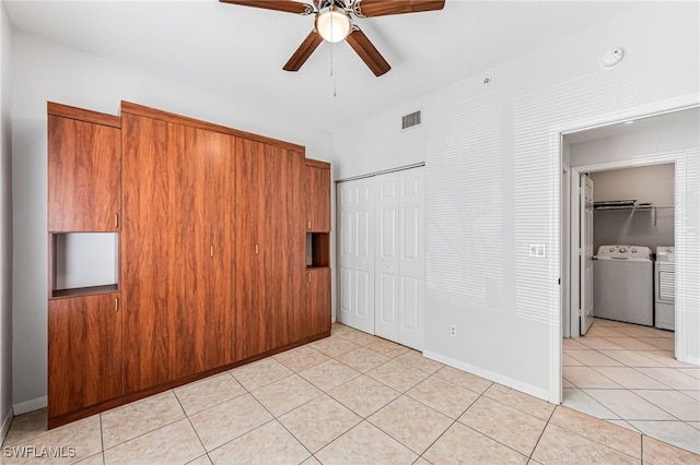 interior space featuring ceiling fan, light tile patterned flooring, and washing machine and dryer