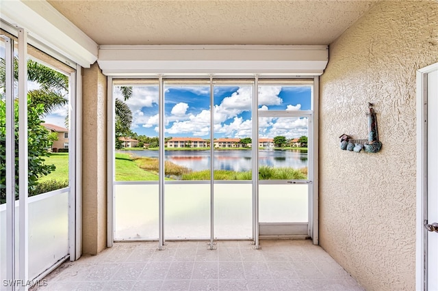 unfurnished sunroom featuring a water view