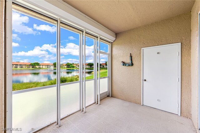 unfurnished sunroom featuring a water view and a wealth of natural light