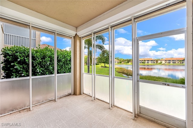 unfurnished sunroom featuring a water view