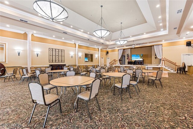 carpeted dining space featuring ornamental molding, a tray ceiling, and decorative columns