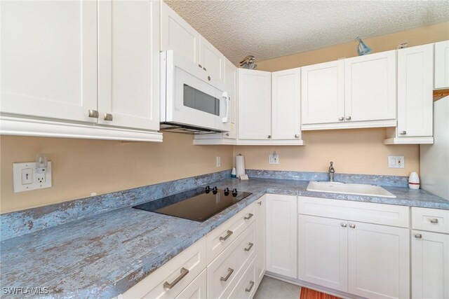 kitchen with white cabinets, a textured ceiling, black electric cooktop, and sink