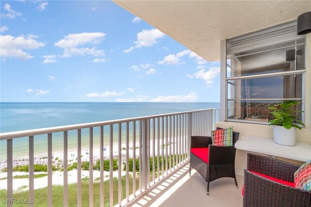 balcony featuring a water view and a beach view