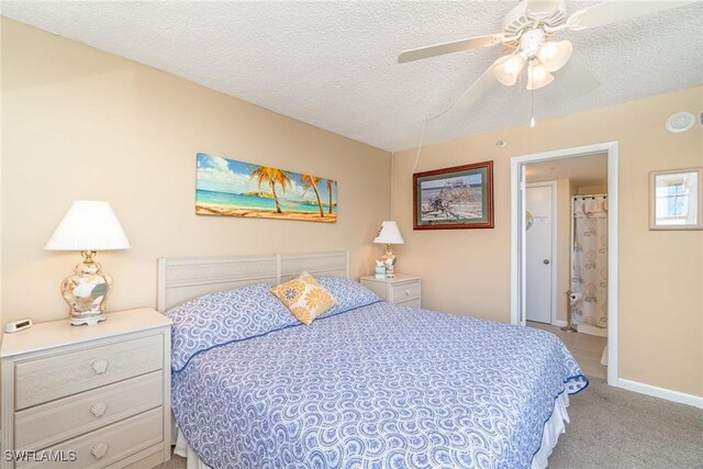 bedroom with ceiling fan, light colored carpet, and a textured ceiling