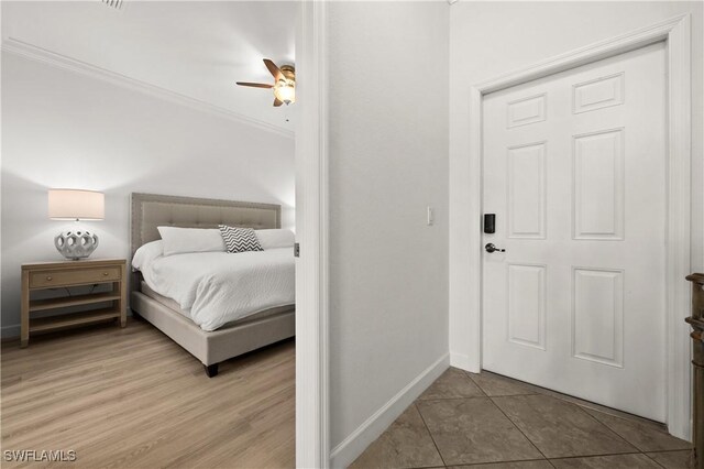 bedroom with ceiling fan, hardwood / wood-style floors, and ornamental molding