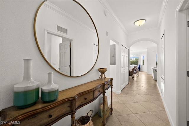 corridor with light tile patterned floors and crown molding