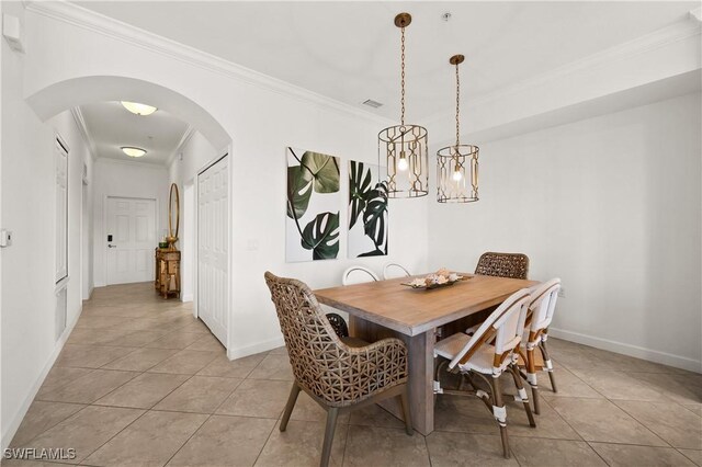 dining area with light tile patterned flooring and ornamental molding