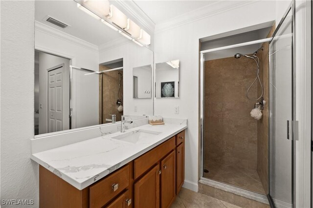 bathroom with crown molding, tile patterned flooring, vanity, and a shower with shower door