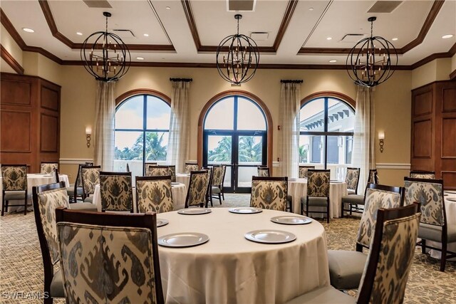 dining area featuring light colored carpet, a raised ceiling, and a chandelier