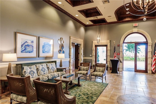 interior space with a towering ceiling, a notable chandelier, and french doors