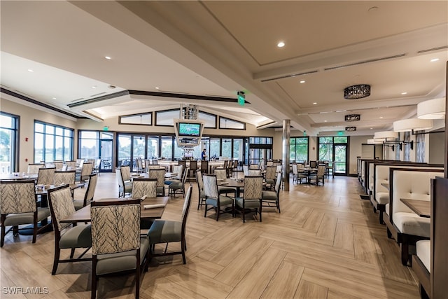 dining room with light parquet flooring and lofted ceiling with beams