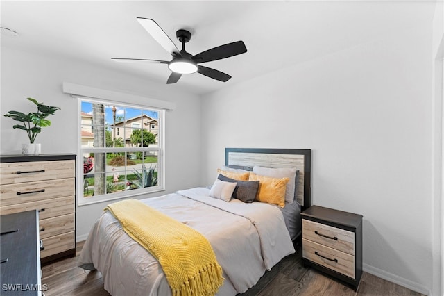 bedroom with dark hardwood / wood-style flooring and ceiling fan