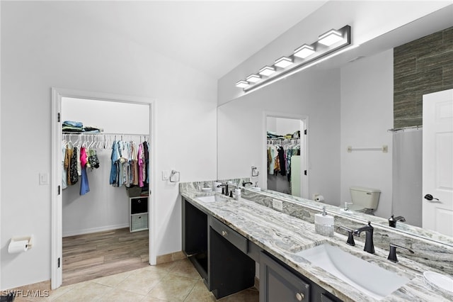 bathroom with double sink vanity, hardwood / wood-style floors, and toilet