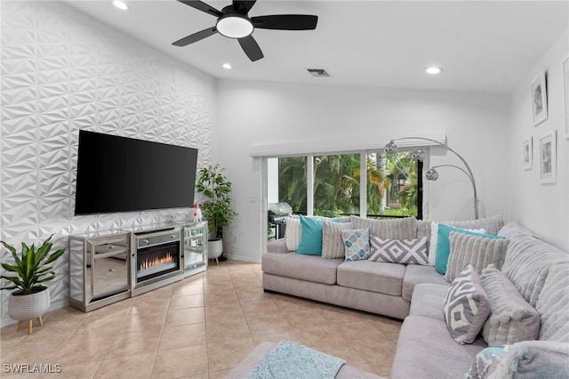 living room with ceiling fan, vaulted ceiling, and light tile patterned flooring