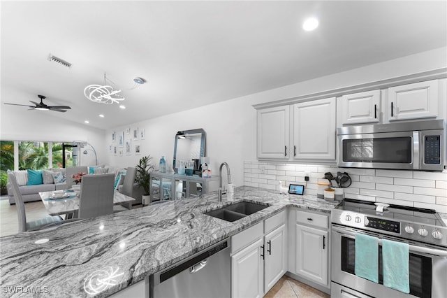 kitchen with sink, tasteful backsplash, ceiling fan, stainless steel appliances, and white cabinets